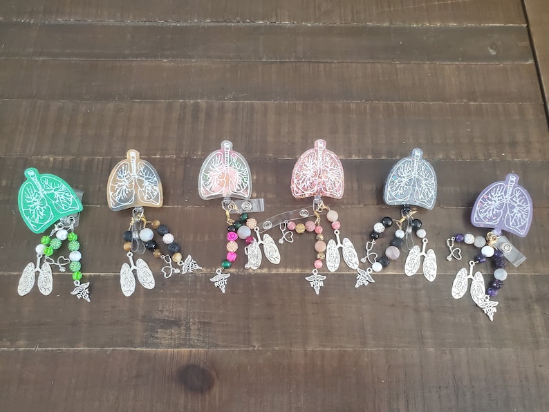 May include: Six colorful lanyards with clear plastic charms shaped like lungs. Each lanyard has a variety of beads and charms, including hearts, stars, and medical symbols.