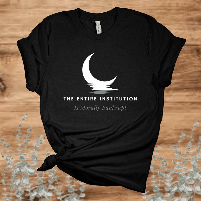 Puede incluir: Camiseta negra con un gr&aacute;fico de luna creciente blanca y el texto "THE ENTIRE INSTITUTION Is Morally Bankrupt".