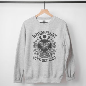 May include: Gray sweatshirt with a black graphic print of a crystal ball with a butterfly inside. The text "Wanderlust" is above the crystal ball and the text "Let's Get Lost" is below the crystal ball.