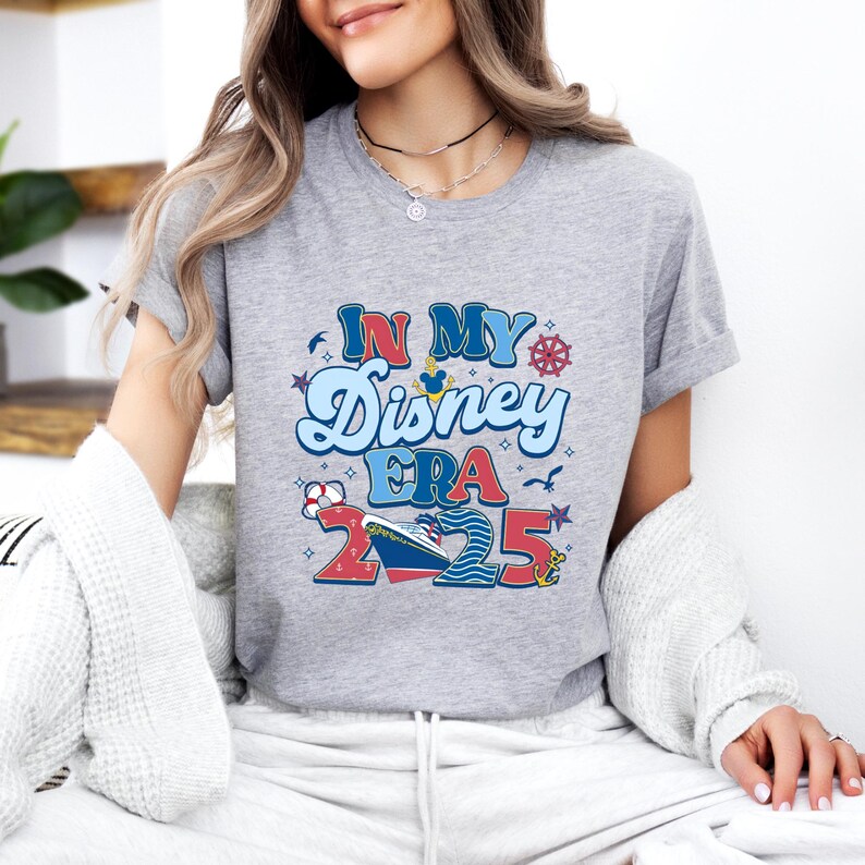 Puede incluir: Camiseta gris con un dise&ntilde;o gr&aacute;fico que dice "In My Disney Era 2025". El dise&ntilde;o presenta un crucero, Mickey Mouse y otros elementos n&aacute;uticos.