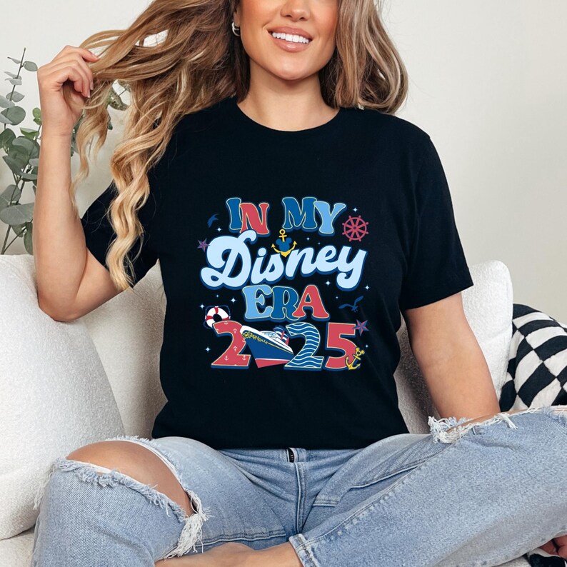 Puede incluir: Una camiseta negra con un gr&aacute;fico colorido que dice "In My Disney Era 2025". El gr&aacute;fico incluye un crucero, un ancla, un salvavidas y estrellas.
