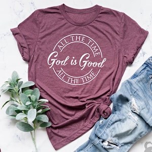 Puede incluir: Camiseta de color marr&oacute;n heather con un gr&aacute;fico circular blanco que dice "All the time God is good All the time".