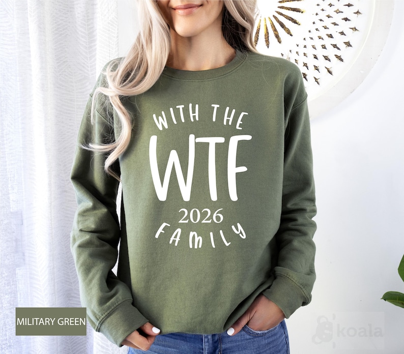 A woman wearing a green sweatshirt with the text "WTF 2026 FAMILY" printed on it.