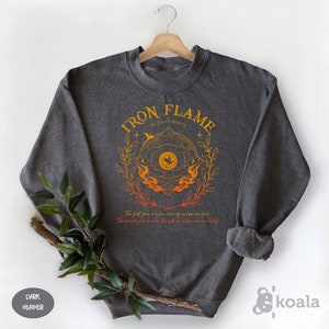 a sweatshirt with iron flame on it next to a plant