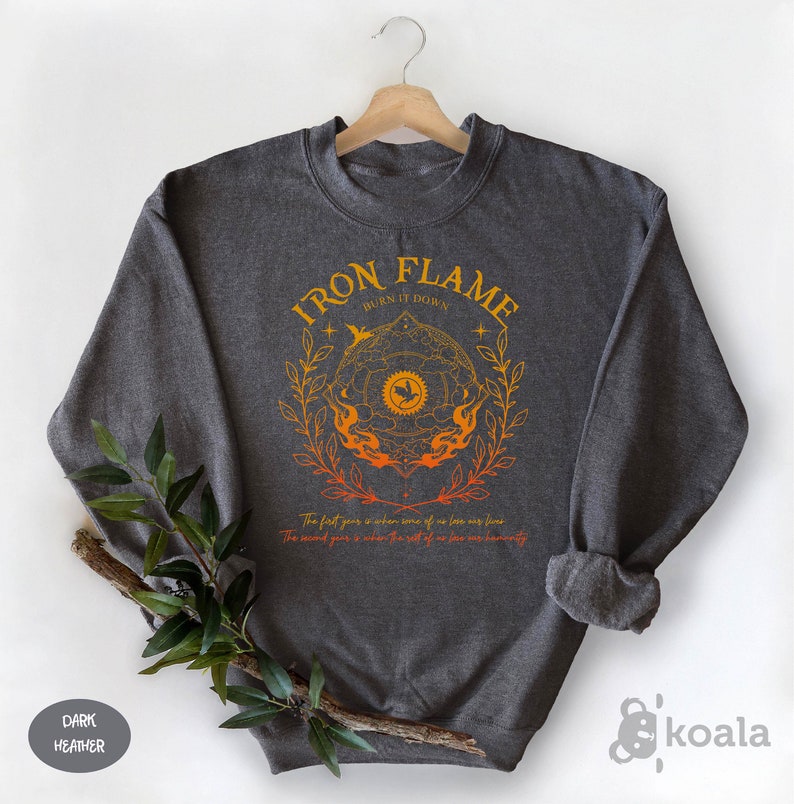a sweatshirt with iron flame on it next to a plant