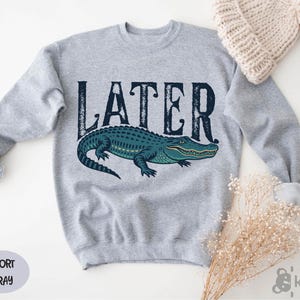 a sweater with the word later on it