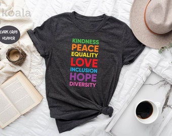 May include: Dark gray heather t-shirt with the words "Kindness, Peace, Equality, Love, Inclusion, Hope, Diversity" printed in rainbow colors.