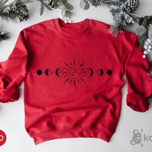 a red sweatshirt with the phases of the moon on it