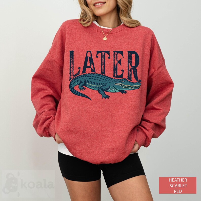 a woman wearing a red sweater with an alligator on it