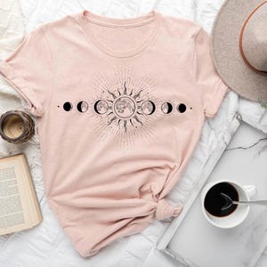a pink shirt with the phases of the moon on it