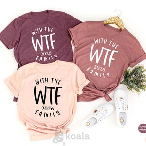 three t-shirts with the text "With the WTF 2016 Family" printed on them, along with a pair of white sneakers and a gold hanger.