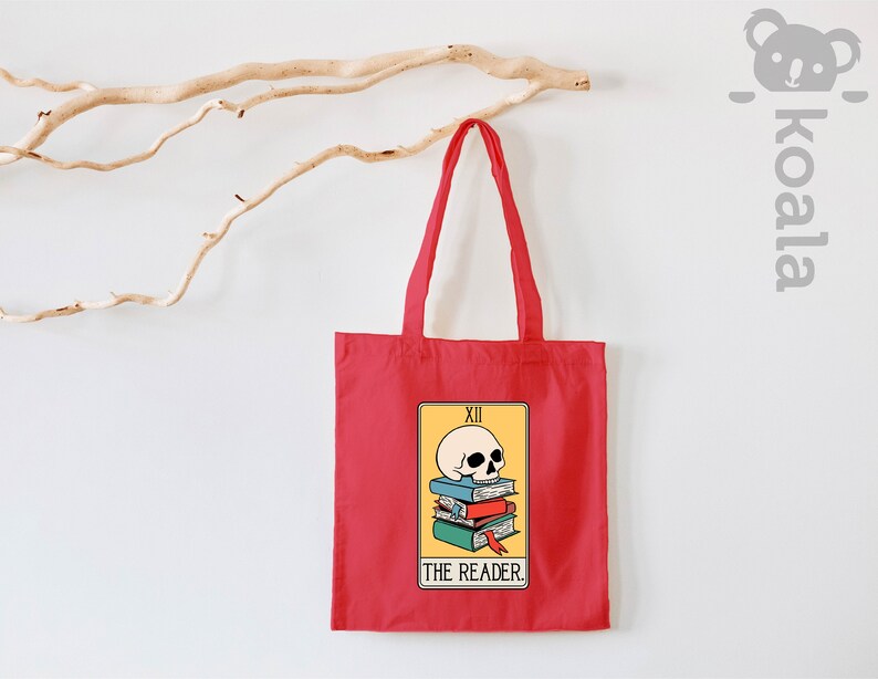 May include: Red tote bag with a yellow tarot card design featuring a skull on top of a stack of books. The card reads "XII THE READER."