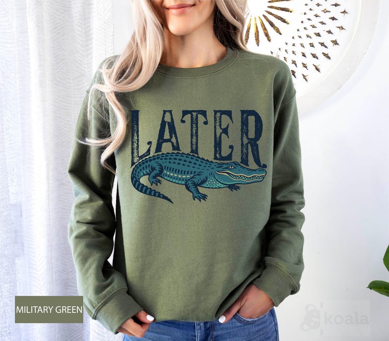 a woman wearing a green sweater with a blue alligator on it