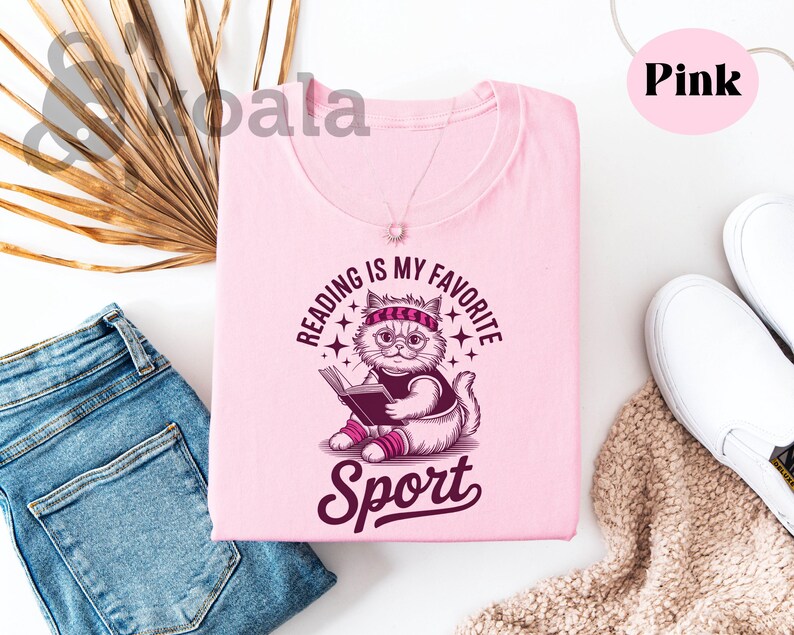 a pink t-shirt with a cat graphic and the text "Reading is my favorite sport" printed on it, along with a pair of jeans and a pair of white sneakers.