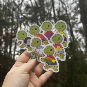 May include: A collection of colorful turtle stickers with different designs. The turtles are all smiling and have different colored shells. The stickers are perfect for adding a touch of whimsy to any surface.