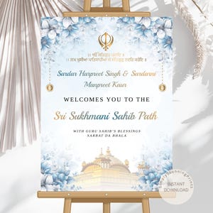 May include: A welcome sign on a wooden easel, featuring a floral design with blue and white flowers. The sign includes text in English and another language, with the names "Sardar Harpreet Singh & Sardarni Manpreet Kaur" and "Sri Sukhmani Sahib Path".