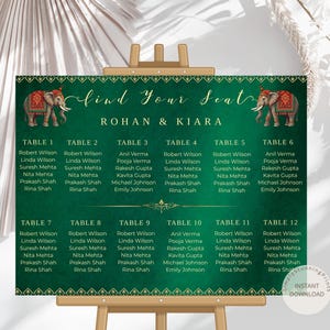 May include: A green wedding seating chart with gold accents and the text "Find Your Seat" above the names of the guests. Two elephant illustrations are on either side of the text. The names are organized by table number.