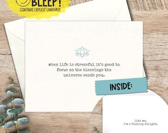 May include: A greeting card with a blue lotus flower graphic and the text "when life is stressful it's good to focus on the blessings the universe sends you." The inside of the card reads "like me. i'm a fucking delight."