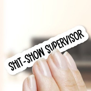 May include: White sticker with the text "SHIT-SHOW SUPERVISOR" in black lettering.