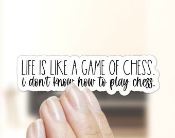 May include: White sticker with black text that reads "LIFE IS LIKE A GAME OF CHESS. i don't know how to play chess."