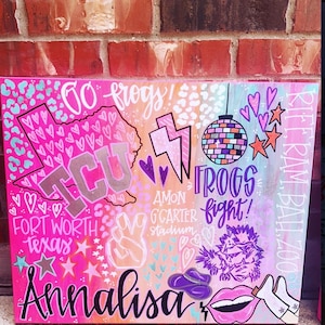 Könnte beinhalten: Ein pinkfarbenes und violettes Leinwandgemälde mit den Worten "Go Frogs!" und "Frogs Fight!" in weißer Schrift. Das Gemälde enthält auch einen lila Frosch, eine Discokugel, ein Peace-Zeichen und die Worte "Fort Worth Texas" und "Amon G Carter Stadium".