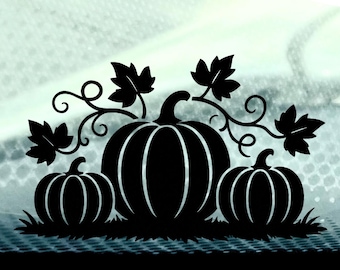 May include: A black vinyl decal featuring a central large pumpkin flanked by two smaller pumpkins. The design includes detailed stems, curling vines, and several leaves, all resting on a patch of grass. The graphic is solid black.