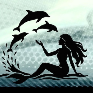 May include: A black silhouette of a mermaid seated in water, with long flowing hair and one arm raised towards three leaping dolphins. Water splashes around the mermaid and dolphins, creating a dynamic scene against a textured background.