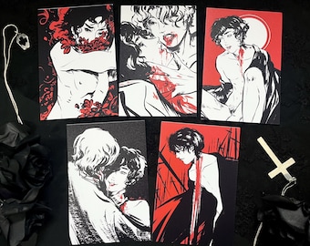 May include: Set of five art prints featuring illustrations in black, white, and red. The prints depict figures in various poses, with a gothic or romantic theme. A silver pendant and a cross-shaped charm are also visible.
