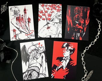 May include: A collection of five art prints featuring black and white illustrations with red accents. The prints depict figures with gothic and horror themes, including a figure with candles, a figure with a tree, and a figure with hands.