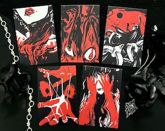 May include: A collection of five art prints with striking red and black illustrations. The prints feature various gothic and horror-themed imagery, including a woman's face, eyes, hands, and abstract figures. The prints are arranged on a black surface, with a silver chain and black rose.