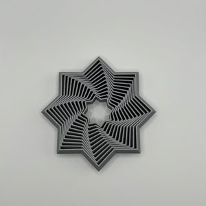 May include: A silver-colored, 3D printed, eight-pointed star with a layered design. The star has a central hole and is made of multiple layers of overlapping points.