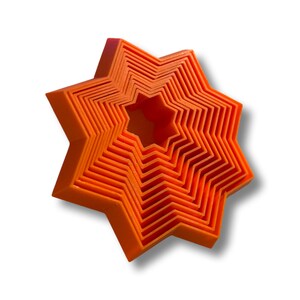 May include: A set of eight orange star-shaped cookie cutters, nested together in decreasing size.