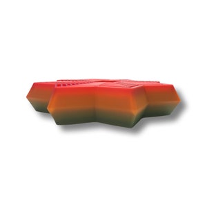 May include: A star-shaped, multi-colored candle with a red, orange, and green gradient. The candle is made of wax and has a smooth, polished finish.