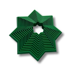 May include: A set of eight green star-shaped cookie cutters, nested inside each other, with the smallest cutter in the center.