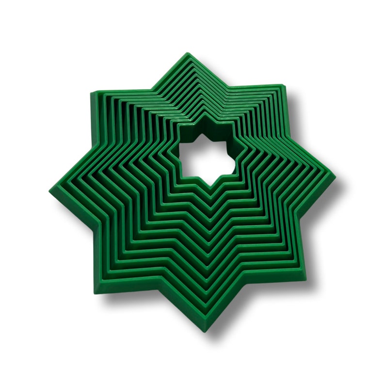 May include: A set of eight green star-shaped cookie cutters, nested inside each other, with the smallest cutter in the center.