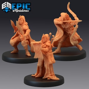 May include: Three miniature figures of fantasy characters, each with a different weapon and pose. The figures are painted in a light brown color and are standing on black bases.