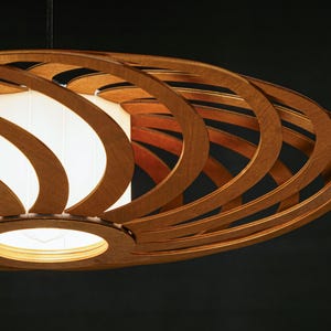 Stylish wooden ceiling lamp with warm, diffused lighting. Handcrafted from sustainable plywood for modern and Scandinavian interiors. A unique pendant light fixture that adds depth and character to any room.