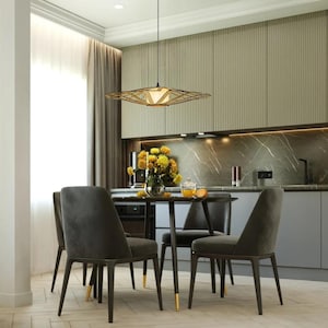 Op de afbeelding: Een moderne eetkamer met een tafel van donker hout en vier grijze stoelen. Een geometrische lamp hangt boven de tafel. De kamer heeft een lichtgroene muur en een marmeren aanrecht.