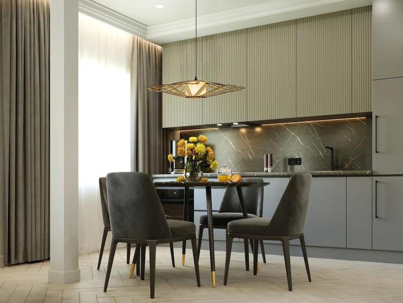 Op de afbeelding: Een moderne eetkamer met een tafel van donker hout en vier grijze stoelen. Een geometrische lamp hangt boven de tafel. De kamer heeft een lichtgroene muur en een marmeren aanrecht.