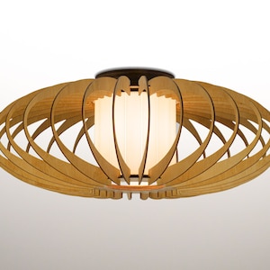 May include: A wooden ceiling light fitting with a white frosted glass shade. The light fitting is made of thin strips of wood that are arranged in a circular pattern.
