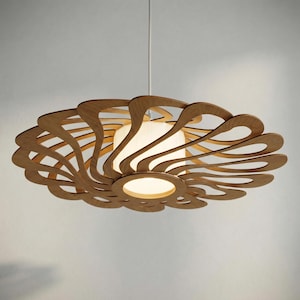 May include: A modern, wooden pendant light fixture. The light features a layered, swirling design in a natural wood tone, surrounding a central, glowing white light source. The fixture is suspended from a white cord.