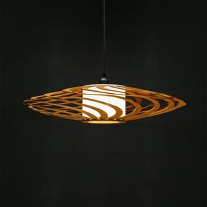 Contemporary wooden ceiling light featuring geometric laser-cut layers. A statement piece for Scandinavian, loft, or boho-style interiors. Handmade from sustainable plywood for a warm and cozy atmosphere.
