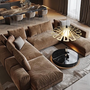 Op de afbeelding: Een grote bruine hoekbank met een zwarte marmeren salontafel en een gouden geometrische hanglamp erboven. De bank is in een L-vorm geplaatst en heeft verschillende kussens en kussens.