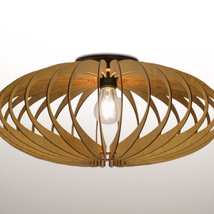 May include: A wooden ceiling light fixture with a circular, open-weave design. The light fixture has a single light bulb in the center.