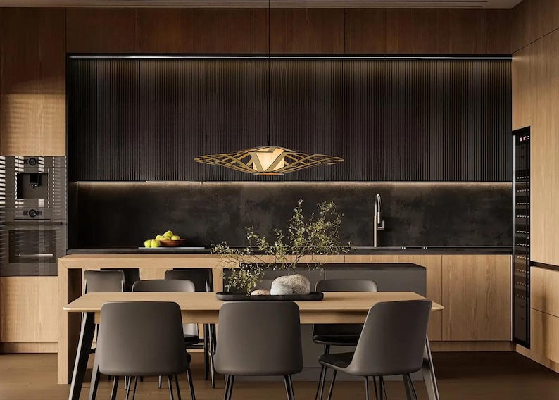 Op de afbeelding: Een moderne eetkamer met een houten tafel en stoelen. De tafel is gedekt met een vaas met bloemen en een kom met fruit. Een grote, geometrische lamp hangt boven de tafel.