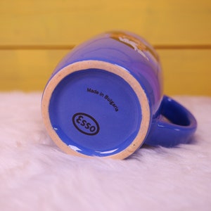 May include: Blue ceramic mug with a white logo that says "Esso" and the text "Made in Bulgaria".