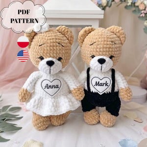 Op de afbeelding: Twee gehaakte teddyberen van beige garen met witte snuiten en zwarte neuzen. De linker beer draagt een witte jurk met een hartvormige patch met de naam Anna. De rechter beer draagt een zwarte tuinbroek met een hartje met de naam Mark. Tekst PDF PATTERN.