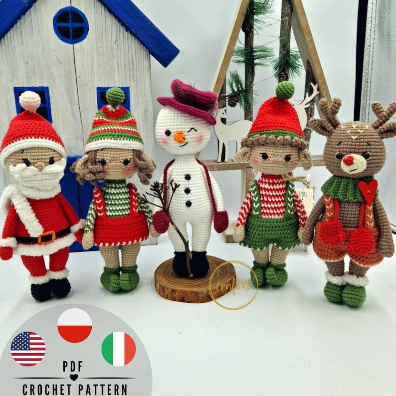 May include: Five handmade crochet Christmas dolls are displayed. The dolls include Santa Claus, a girl in a red dress, a snowman, an elf, and a reindeer. Each doll has unique features and is wearing festive outfits. The dolls are standing in front of a white background.
