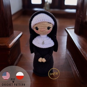 Puede incluir: Patrón de crochet PDF para una muñeca amigurumi de monja. La muñeca lleva un hábito negro con un velo blanco y una cruz en el pecho. La muñeca tiene una cara dulce y sonriente con ojos marrones y mejillas sonrosadas.