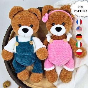 May include: Two brown plush teddy bears made of soft yarn. The left bear wears white sleeves and teal overalls with wooden buttons. The right bear wears a pink headband with a flower and pink overalls with white ruffles and wooden buttons. Text reads PDF PATTERN.